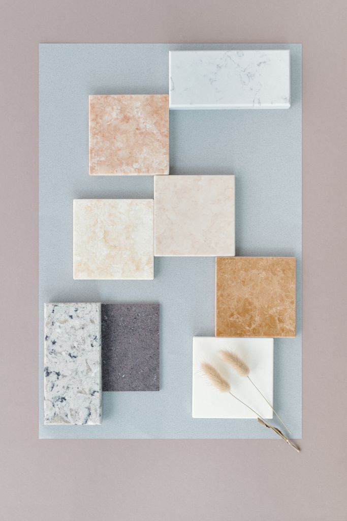 Flat lay of various marble tiles arranged on a soft neutral backdrop for design inspiration.